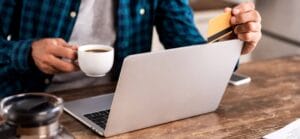 Man with coffee online shopping with credit card