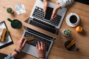 table with 2 people working on laptop